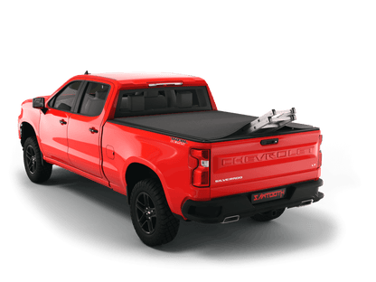 Red Chevrolet Silverado 2500HD / 3500 HD / GMC Sierra 2500HD / 3500HD with ladder sticking out of Sawtooth Stretch expandable truck bed cover