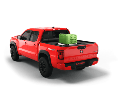 Red Nissan Frontier with gear in the truck bed and the Sawtooth Stretch tonneau cover rolled up at cab 