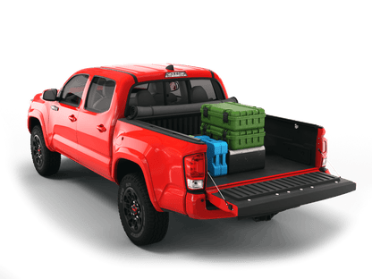 Red Toyota Tacoma with gear in the truck bed and the Sawtooth Stretch tonneau cover rolled up at cab 